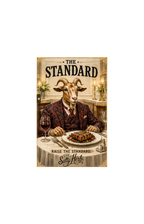 Goat in a suit with a plate of food and glass of wine, sitting at a table with 'The Standard' branding.