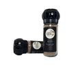 Spice shaker with black lid and visible brand label on a white background